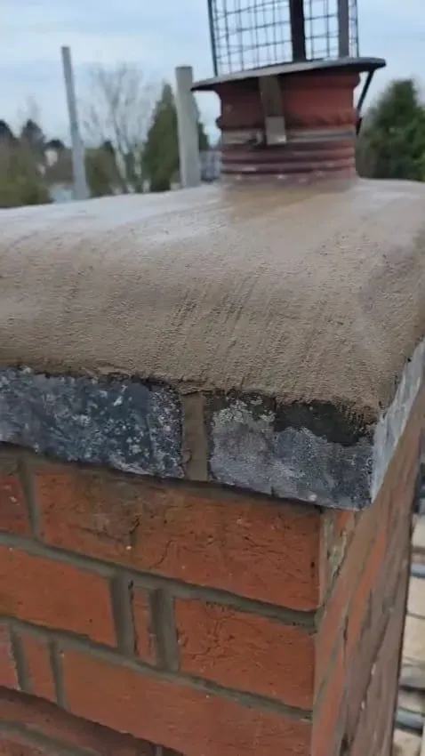 Newly flaunched brick chimney stack with a chimney pot and bird guard on a rooftop.
